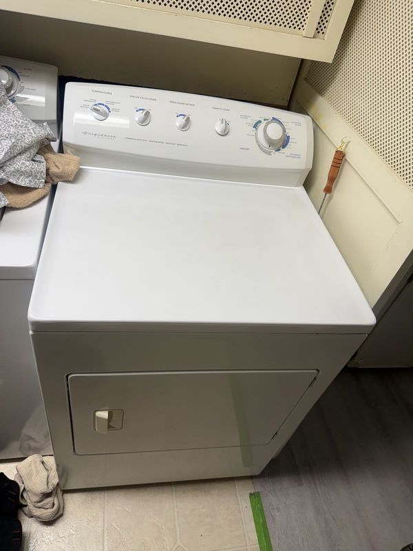 White Frigidaire dryer in a laundry room before repair